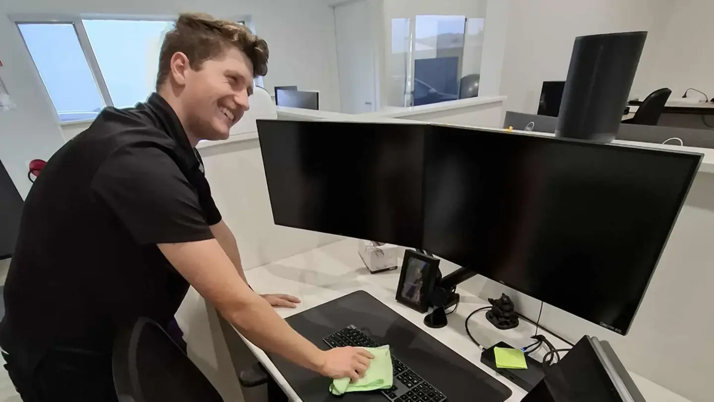 Kaylem from HTE Cleaning working to clean a clients keyboard and desk.